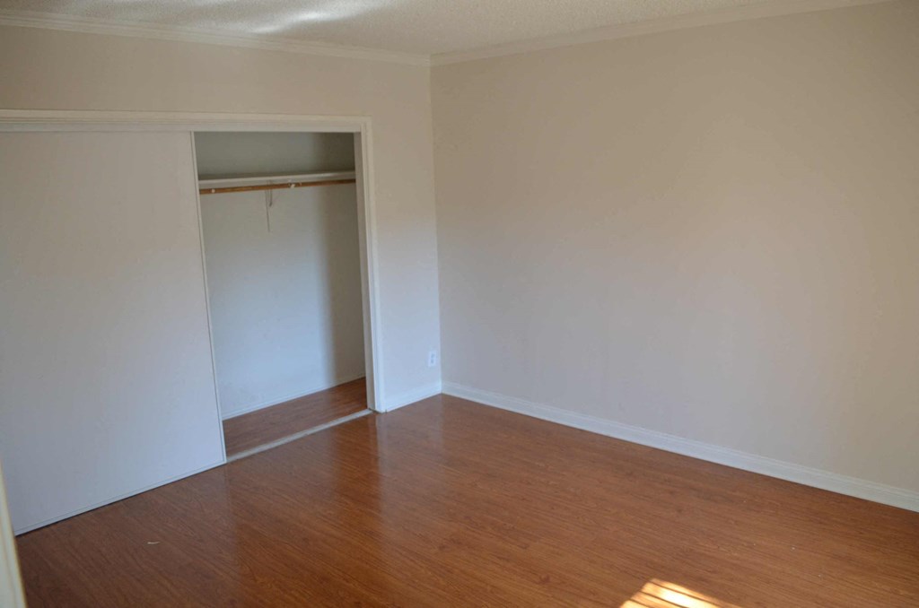 an empty room with wooden floors and a closet