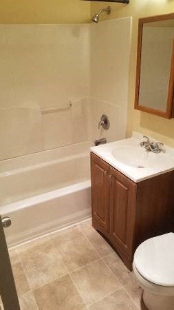 a bathroom with a toilet and a sink and a bath tub