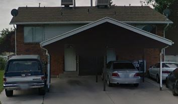 A house with a car parked in front of it.
