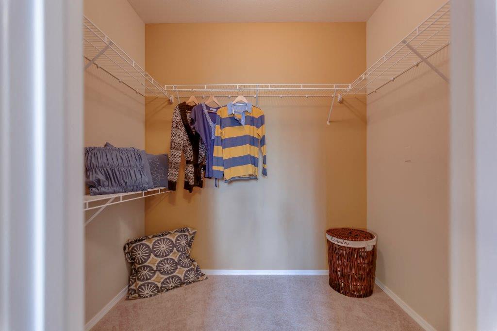 a walk in closet with robes and pillows