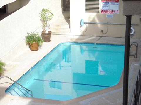 A pool with a caution sign on the wall.