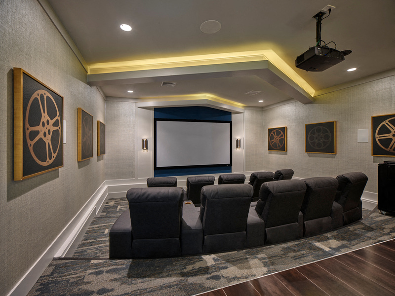 a large screening room with a large couch and a projector screen
