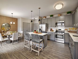 a kitchen with stainless steel appliances and a table with chairs