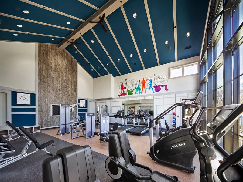 a gym with weights and cardio machines and a sign on the wall