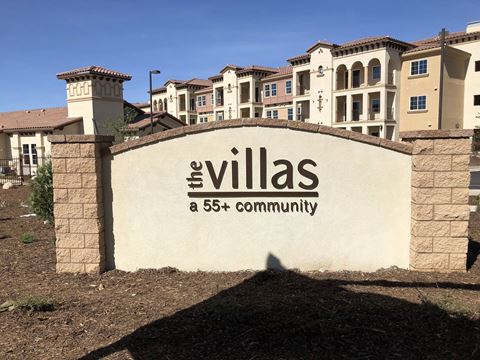 the villas at 565 community sign in front of buildings