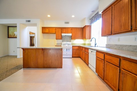 a large kitchen with wooden cabinets and white appliances