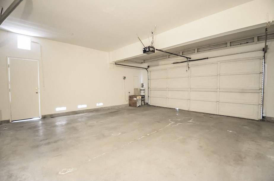 the inside of a garage with white walls and a garage door