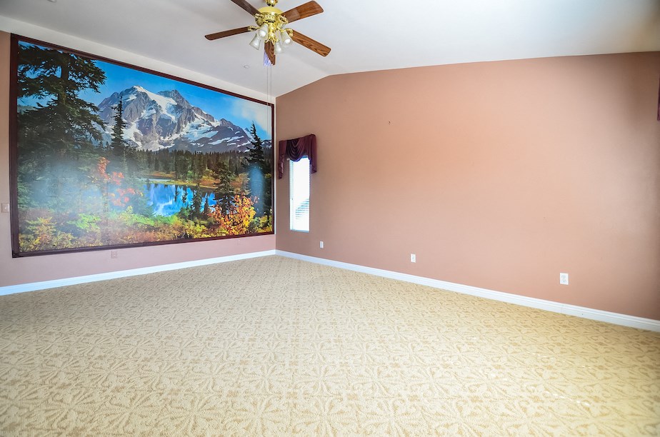 an empty living room with a large painting on the wall