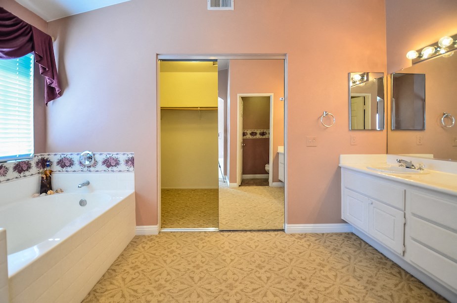 a bathroom with a tub and a sink and a mirror