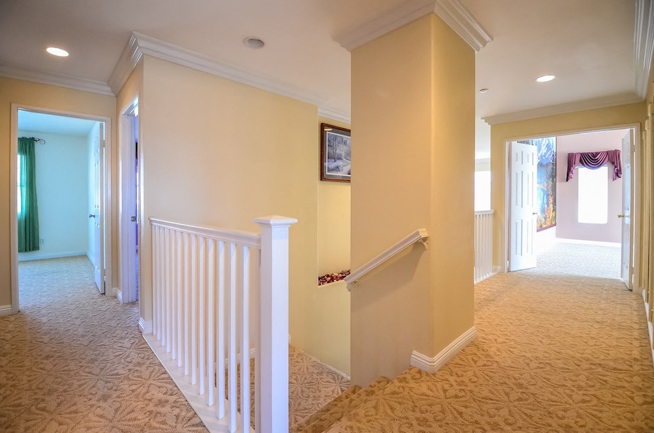 a hallway with a staircase and a hall way and a door to a room with