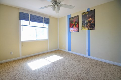 an empty room with a ceiling fan and a window
