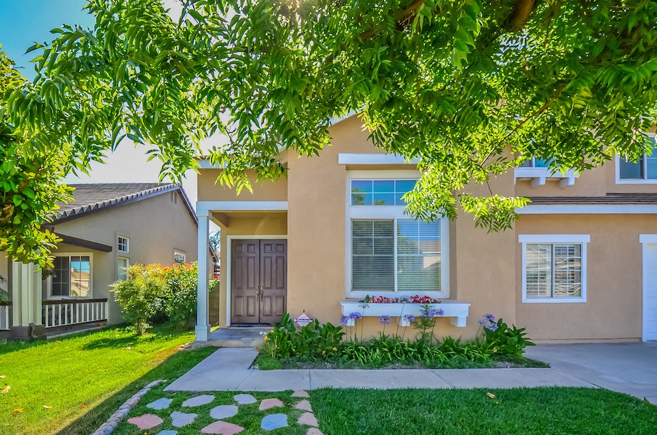 a house with a yard and a bench in front of it