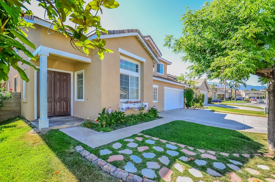 a house with a driveway and lawn in front of it