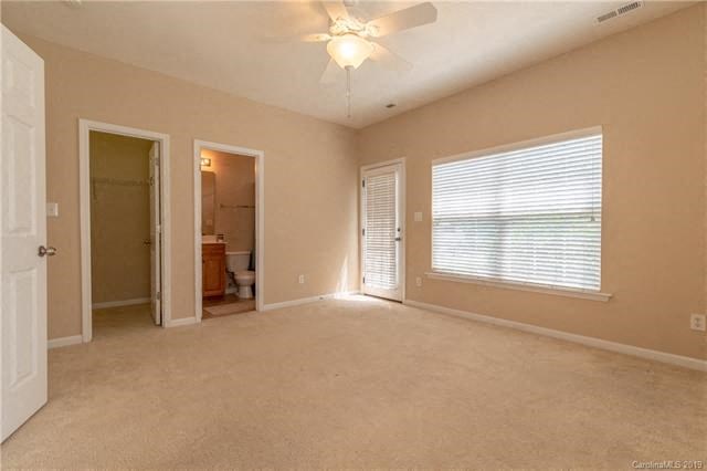 A room with a ceiling fan and a window with blinds.