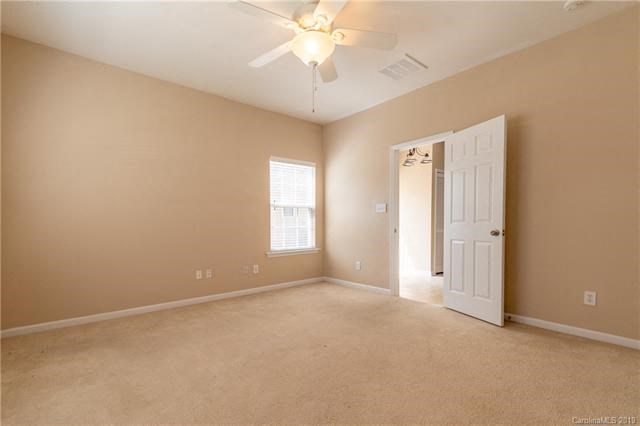 A room with a ceiling fan and a door.