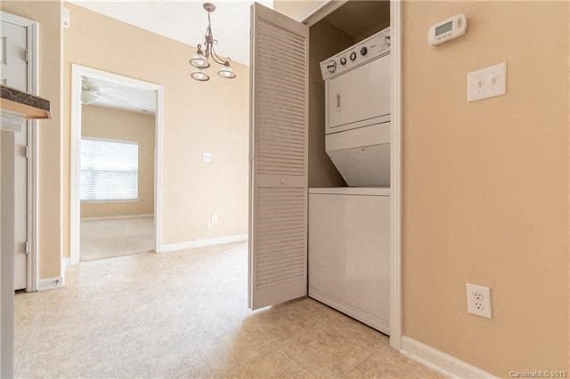 A white refrigerator is in the corner of a room.