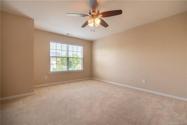Empty room with a ceiling fan and a window.