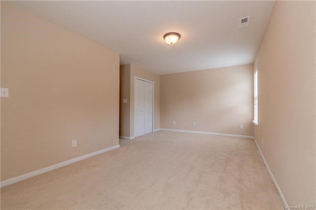 A room with a white door and a light on the ceiling.