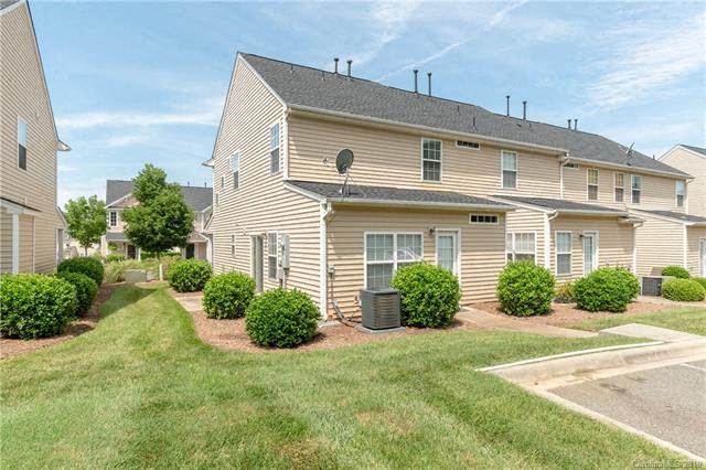 A residential building with a well-maintained lawn and a driveway.