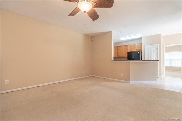 A room with a ceiling fan and a wall-mounted TV.