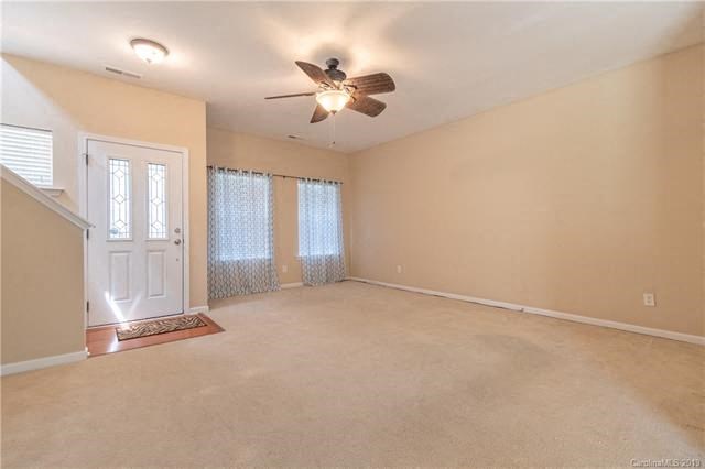 A room with a ceiling fan and a door.