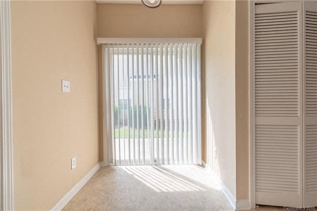 A room with a sliding door and a window with blinds.
