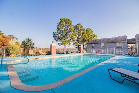 a swimming pool with a house in the background