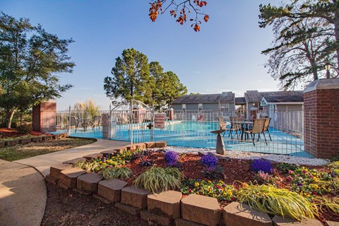 a swimming pool with a fence and chairs around it