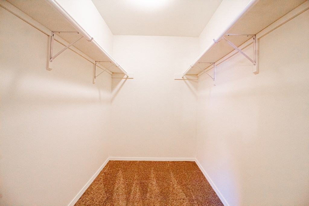 a room with white walls and two shelves on the wall