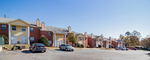 an empty parking lot in front of a row of houses