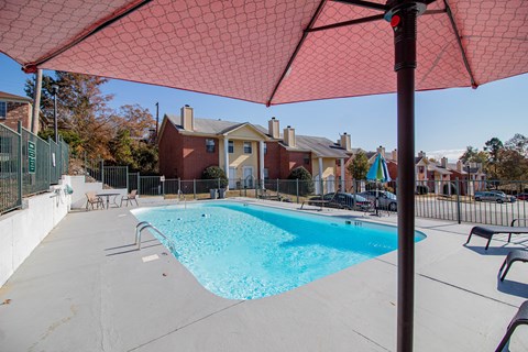 our apartments have a swimming pool with chairs and umbrellas
