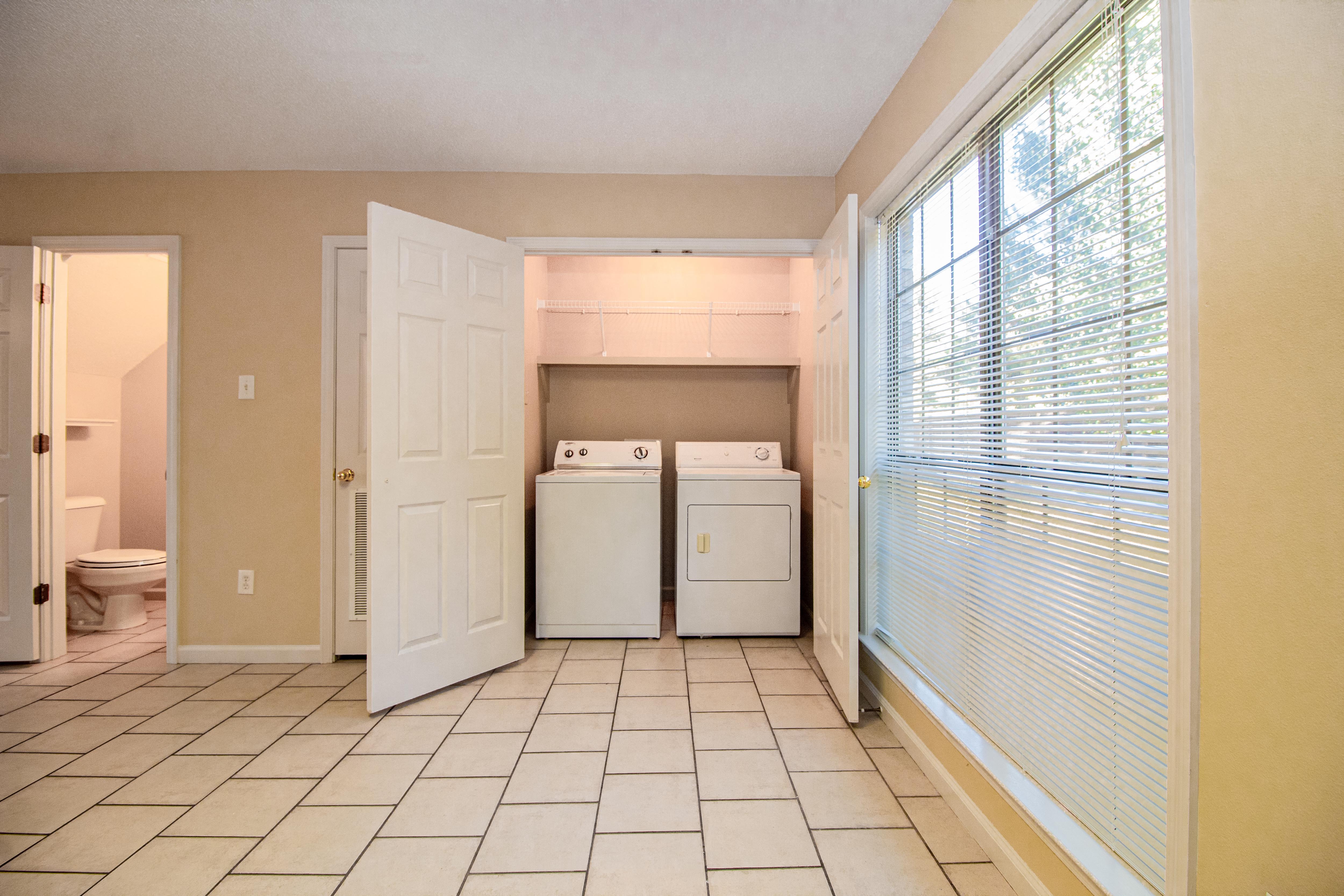 a laundry room with a large window and two washer and dryers