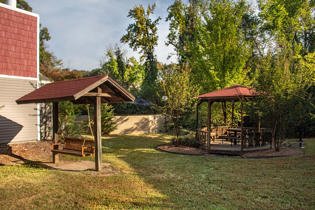 a backyard with a gazebo and a swing set
