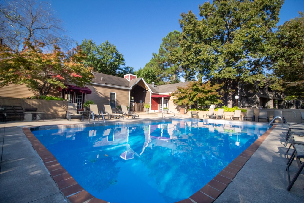 a large swimming pool with a house in the background