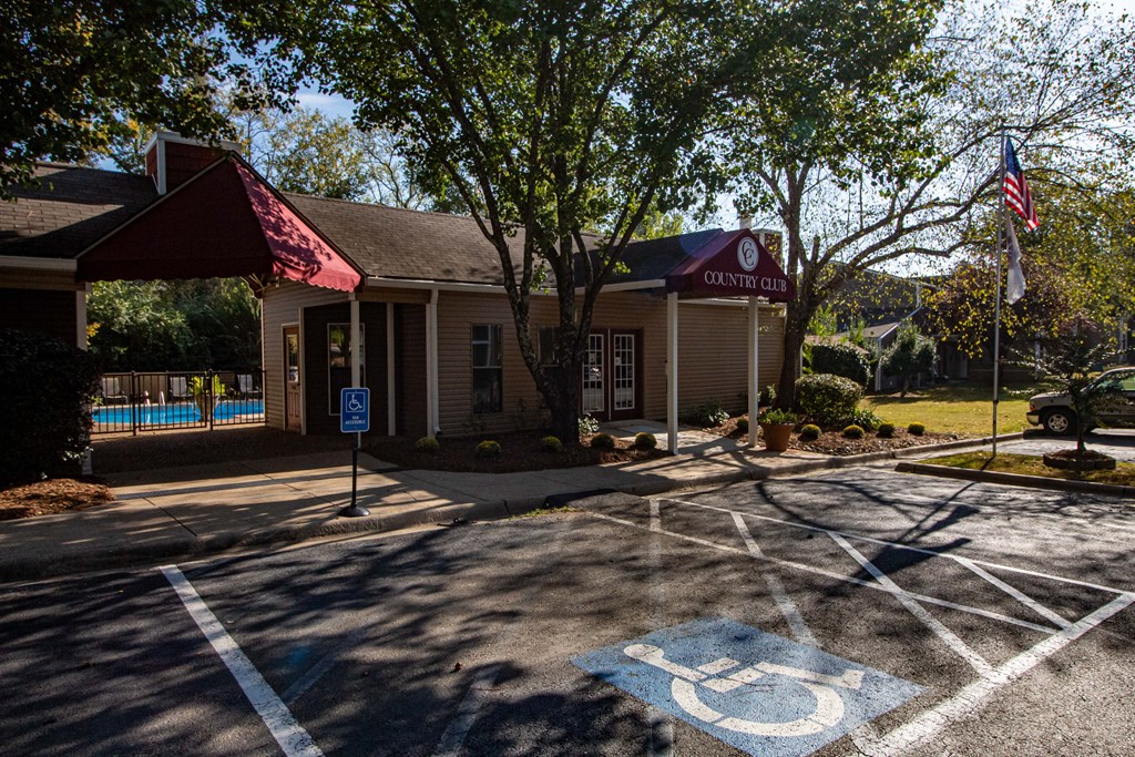 an empty parking lot in front of a building with a swimming pool