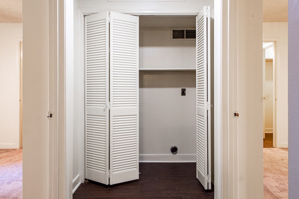 a closet with white shutters in a living room