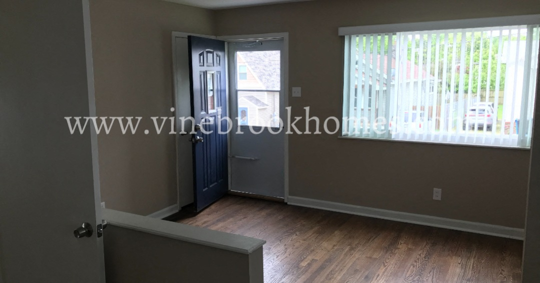 a small living room with a blue door and a window