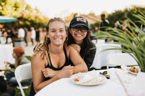 two women sitting at a table eating food