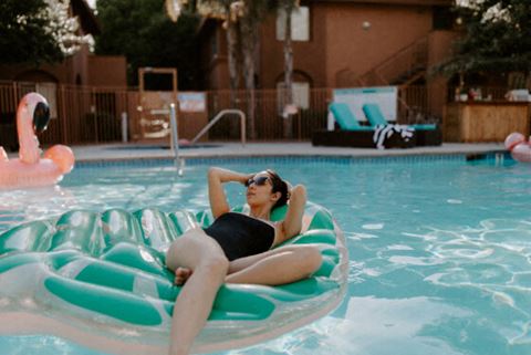 a woman laying on a raft in a swimming pool