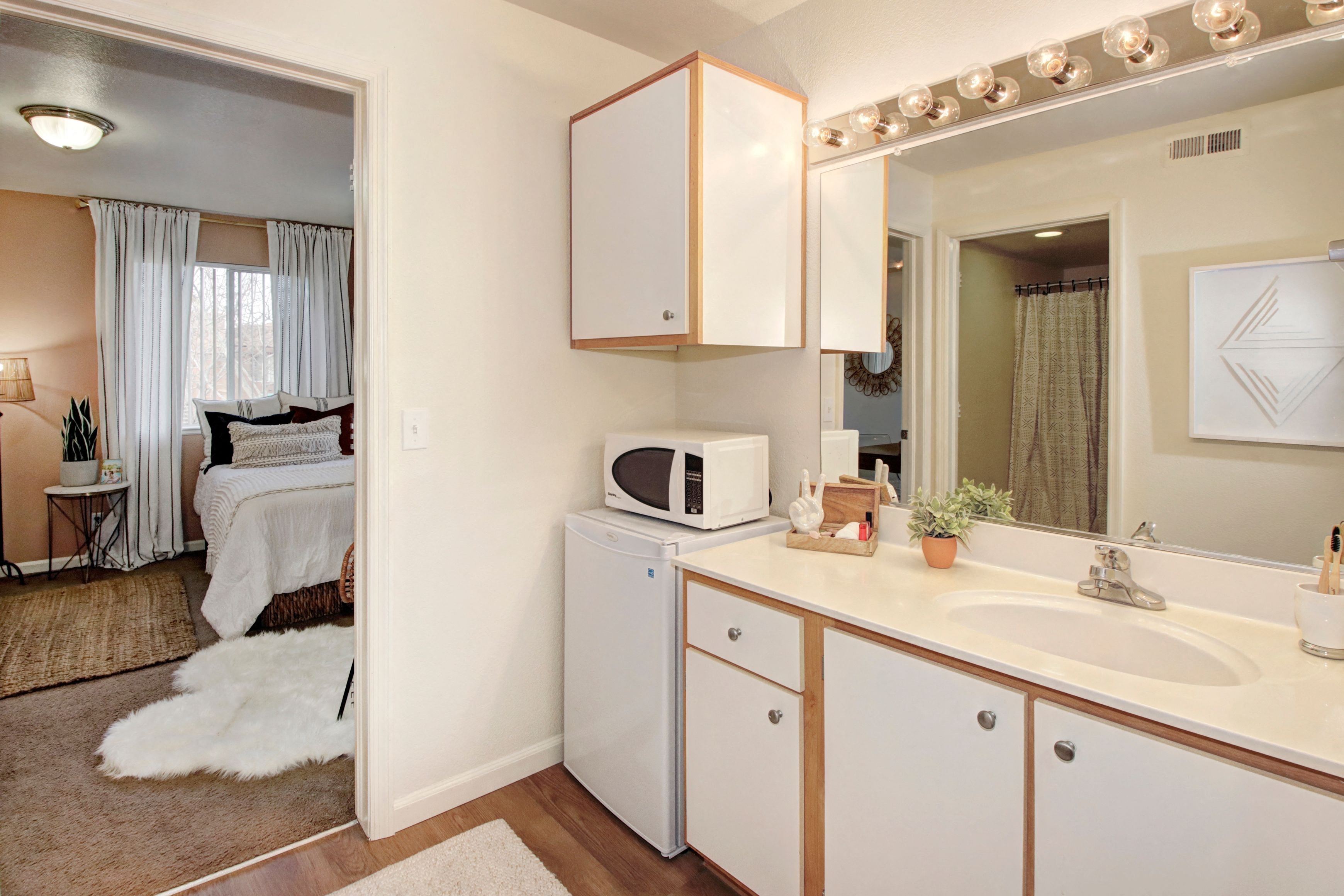a kitchen with white cabinets and a sink and a microwave