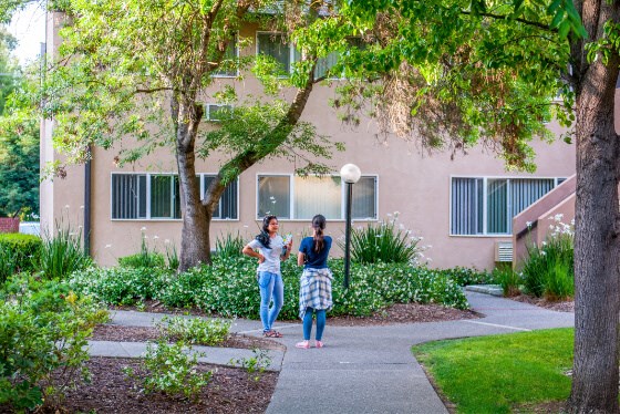 two people standing in front of an apartment building