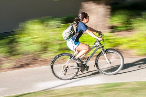 a woman riding a bike down a road