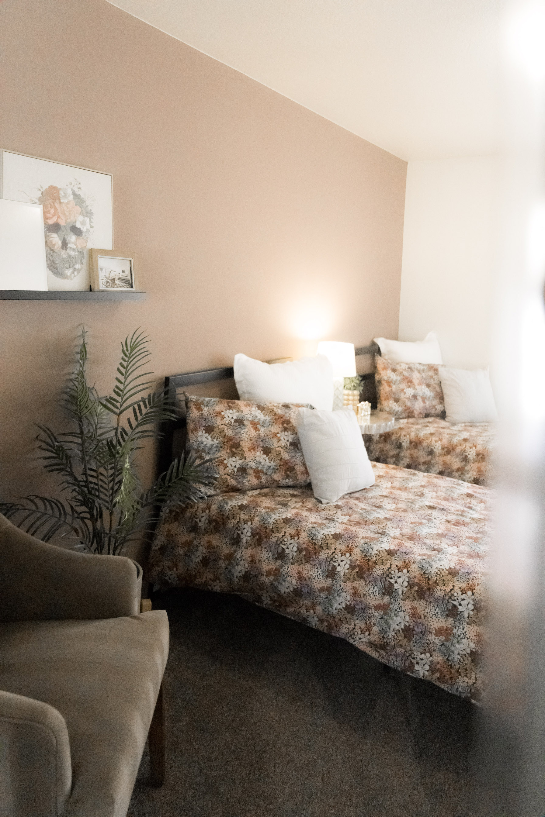 Image of a bedroom with a pink wall and two beds