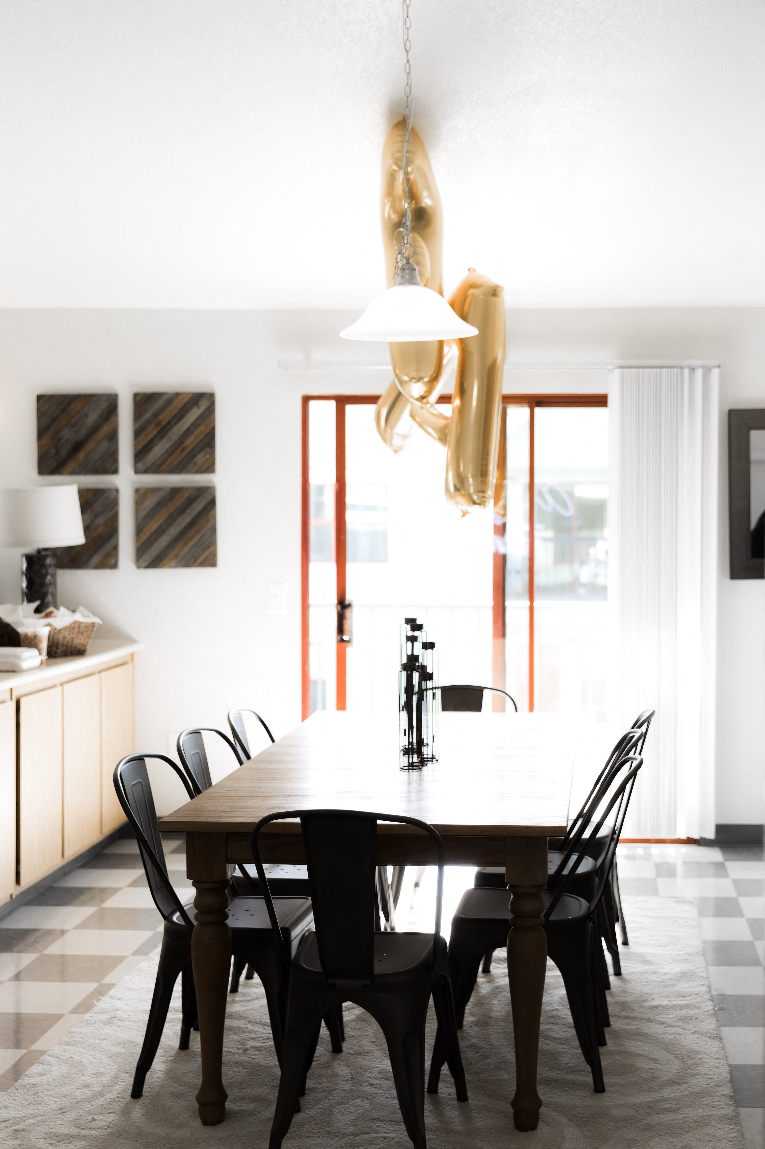 Dining room table and chairs with gold letter A and F balloon floating above