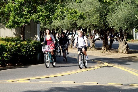 Students biking on the bike path to the UC Davis Campus from The Atriums