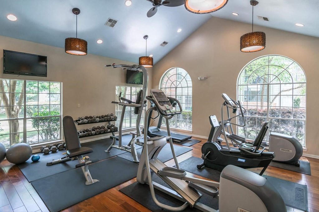 a gym with exercise equipment and windows