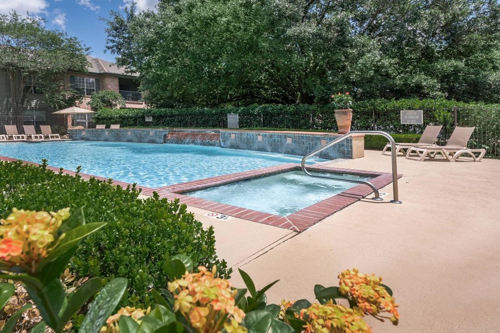 a resort style pool with chairs and a fence around it