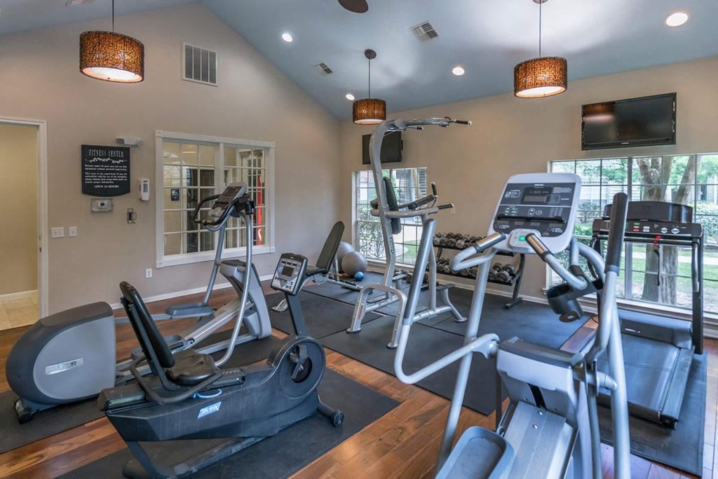 a gym with a lot of machines and a tv