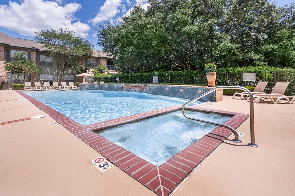 a resort style pool with chairs around it and a building in the background