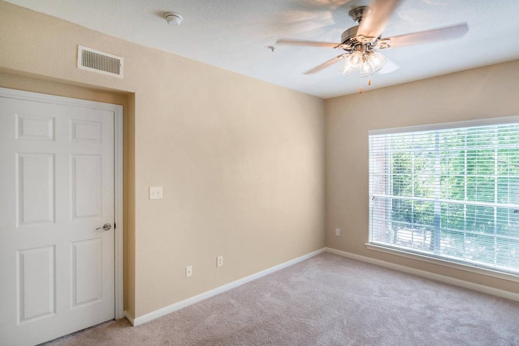 a bedroom with a ceiling fan and a window